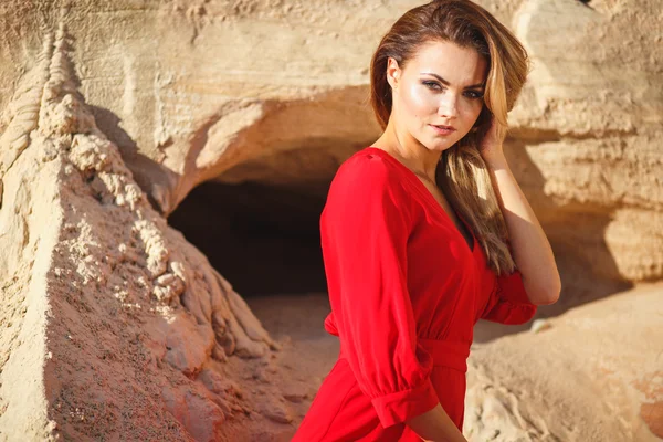 Preciosa mujer joven cabeza roja en vestido largo rojo en un postre. Sandy Canyon. Estilo de moda —  Fotos de Stock