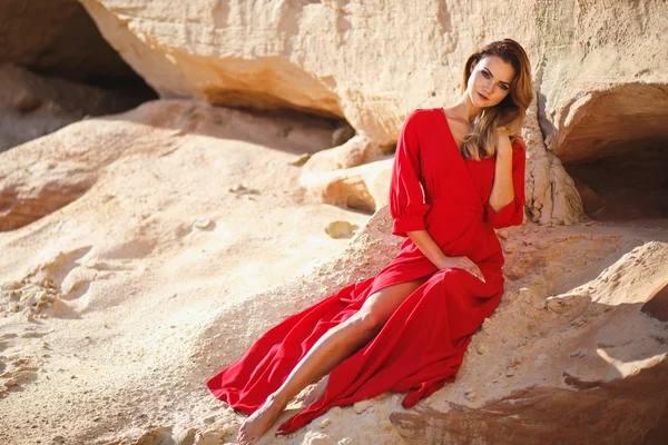 Preciosa mujer joven cabeza roja en vestido largo rojo en un postre. Sandy Canyon. Estilo de moda — Foto de Stock