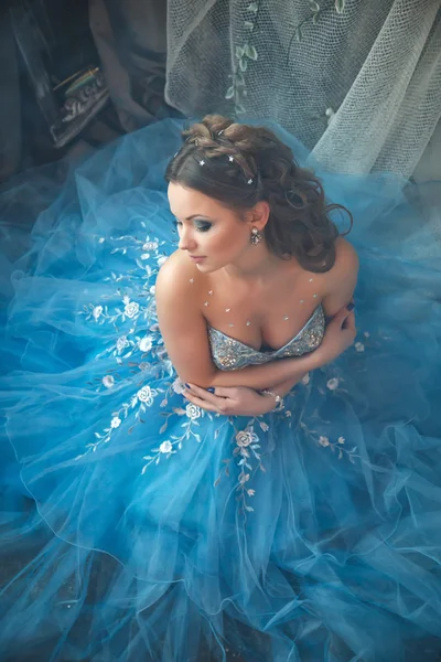 Hermosa mujer joven en vestido largo azul magnífico como Cenicienta con maquillaje perfecto y estilo de pelo —  Fotos de Stock