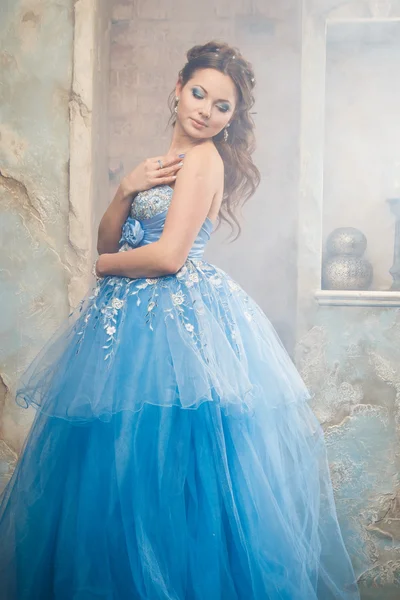 Hermosa mujer joven en vestido largo azul magnífico como Cenicienta con maquillaje perfecto y estilo de pelo —  Fotos de Stock