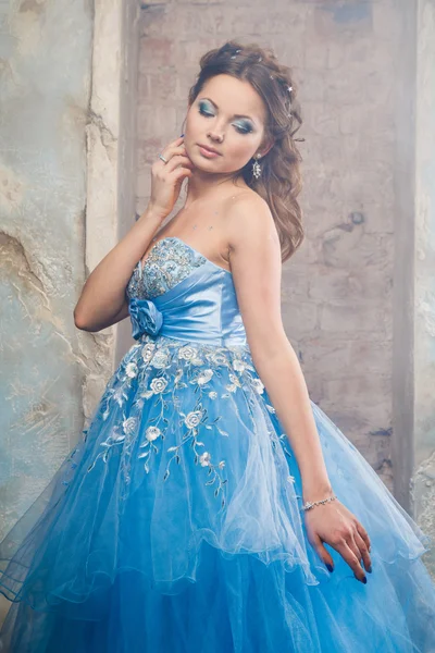 Hermosa mujer joven en vestido largo azul magnífico como Cenicienta con maquillaje perfecto y estilo de pelo —  Fotos de Stock