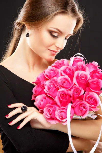 Gros plan portrait de belle jeune femme avec des bijoux de luxe et maquillage parfait tenant bouquet. Mode beauté portrait — Photo