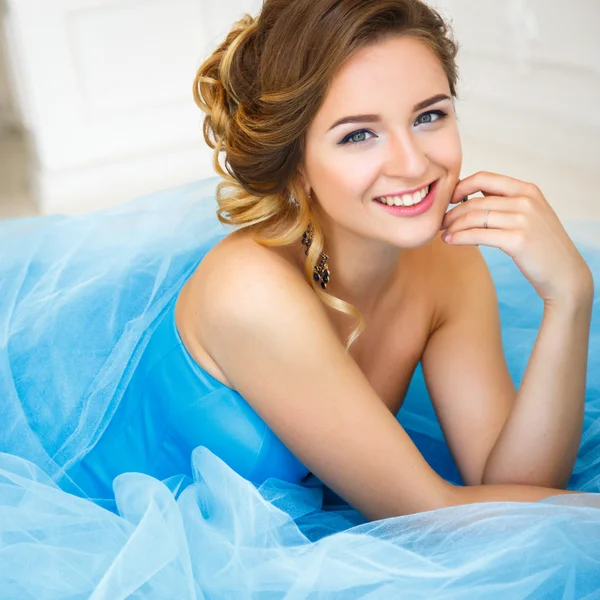 Beautiful bride lying on gorgeous blue dress Cinderella style in a morning — 스톡 사진