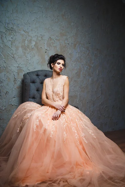 Retrato de una hermosa joven morena en un precioso vestido de moda — Foto de Stock