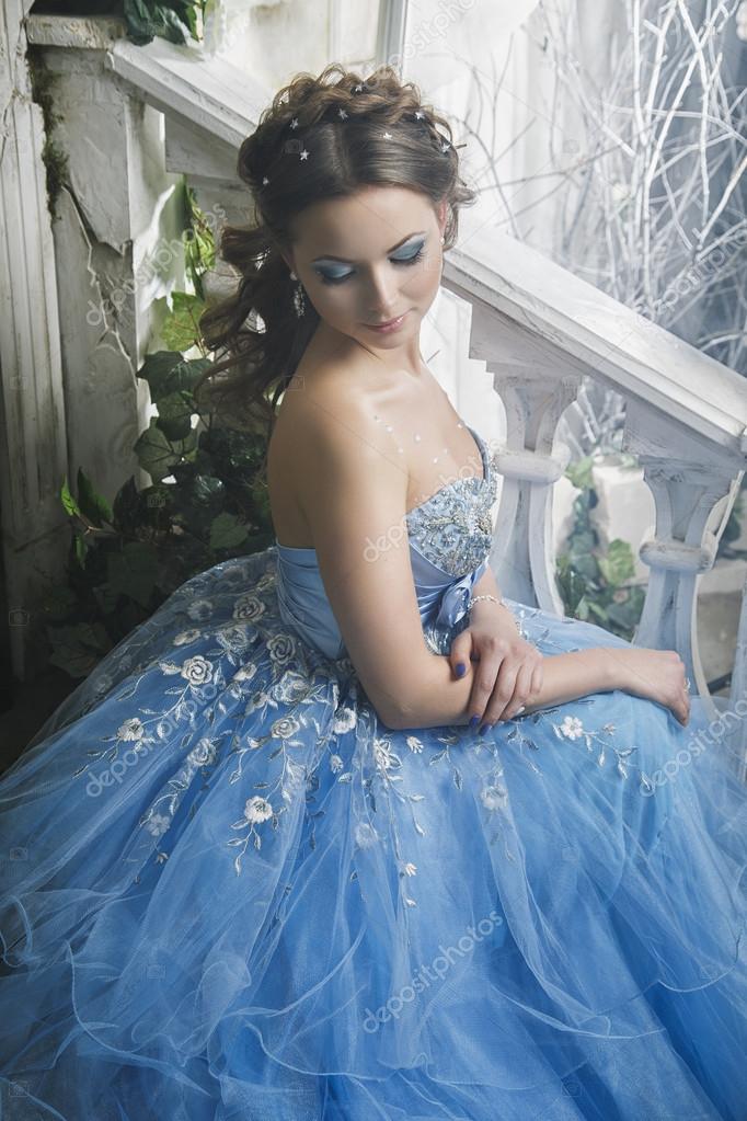 Beautiful young woman in gorgeous blue long dress like Cinderella with  perfect make-up and hair style Stock Photo by ©cherry_daria 91893194