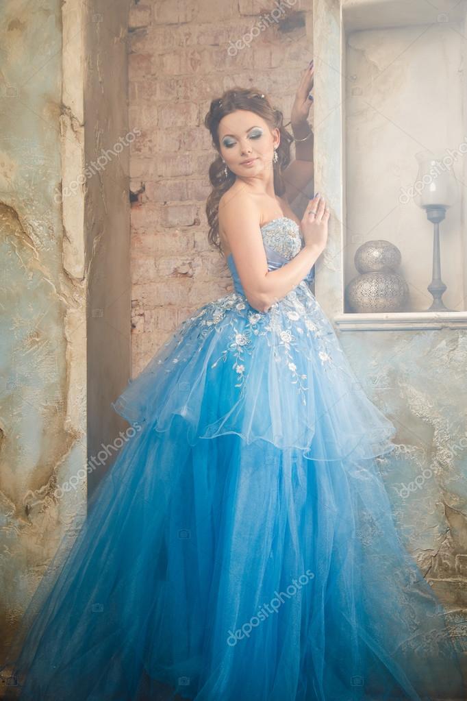 Beautiful young woman in gorgeous blue long dress like Cinderella with  perfect make-up and hair style Stock Photo by ©cherry_daria 91893526