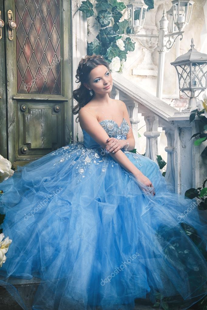 Beautiful young woman in gorgeous blue long dress like Cinderella with  perfect make-up and hair style Stock Photo by ©cherry_daria 91894362