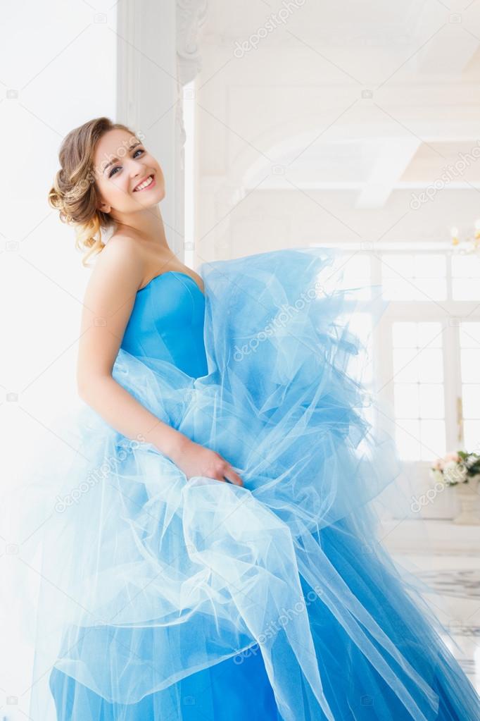 Beautiful bride in gorgeous blue dress Cinderella style in a morning