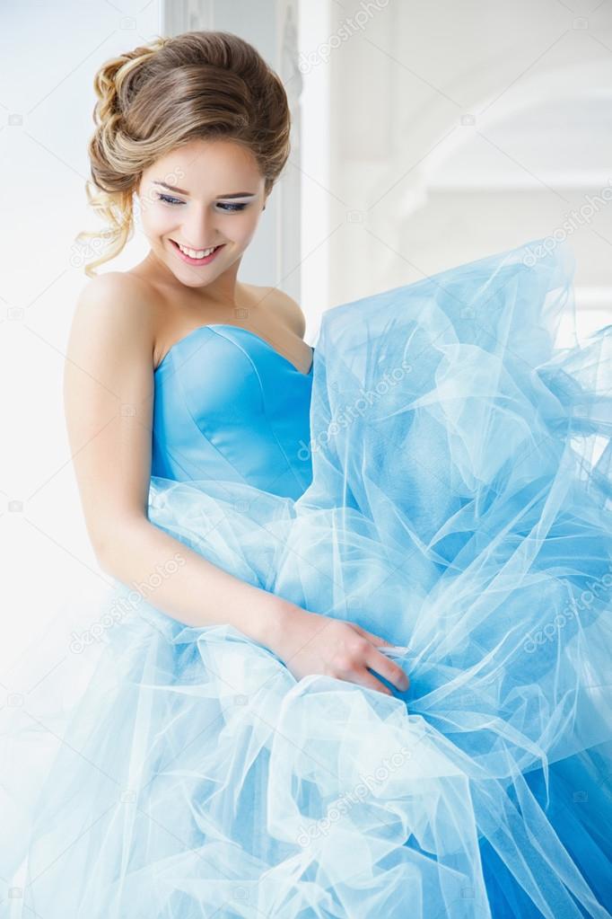 Beautiful bride in gorgeous blue dress Cinderella style in a morning