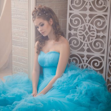 Muhteşem mavi uzun elbiseli güzel genç kadın mükemmel makyajlı ve saç stili olan Cinderella gibi.