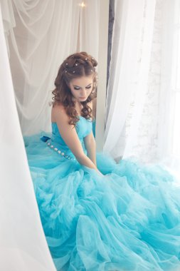 Muhteşem mavi uzun elbiseli güzel genç kadın mükemmel makyajlı ve saç stili olan Cinderella gibi.