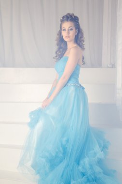 Muhteşem mavi uzun elbiseli güzel genç kadın mükemmel makyajlı ve saç stili olan Cinderella gibi.