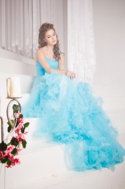 Muhteşem mavi uzun elbiseli güzel genç kadın mükemmel makyajlı ve saç stili olan Cinderella gibi.