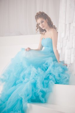 Muhteşem mavi uzun elbiseli güzel genç kadın mükemmel makyajlı ve saç stili olan Cinderella gibi.