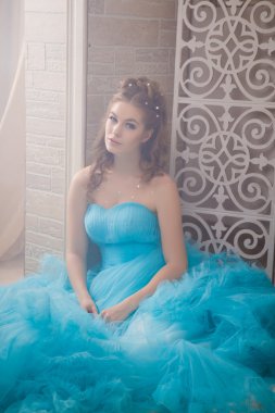 Muhteşem mavi uzun elbiseli güzel genç kadın mükemmel makyajlı ve saç stili olan Cinderella gibi.