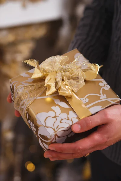 Close up photo of male hands holding a gift