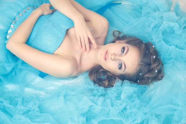 Hermosa mujer joven en vestido largo azul magnífico como Cenicienta con maquillaje perfecto y estilo de pelo —  Fotos de Stock