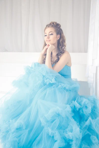Beautiful young woman in gorgeous blue long dress like Cinderella with perfect make-up and hair style — Stock Photo, Image