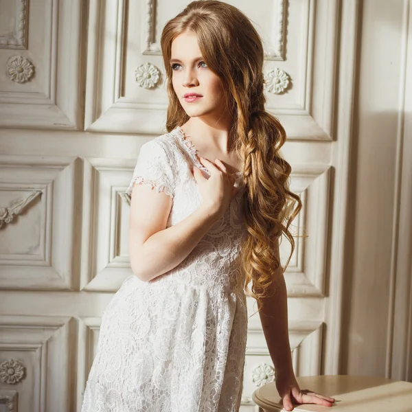 Retrato de una joven bonita en un vestido blanco y pelo largo y rubio —  Fotos de Stock