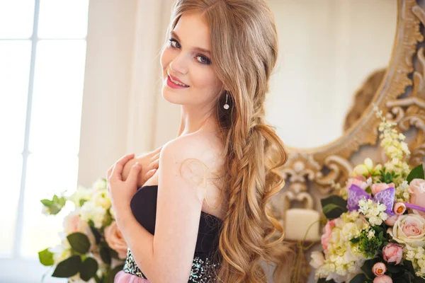 Ritratto di bella ragazza in un bel vestito e lunghi capelli biondi in interni splendidi — Foto Stock