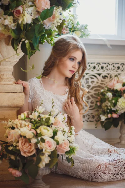 Retrato de una joven bonita en un vestido blanco y pelo largo y rubio rodeado de flores —  Fotos de Stock