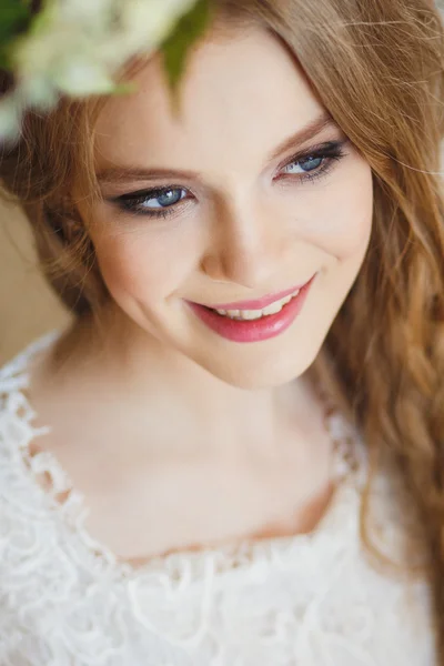 Porträt eines hübschen jungen Mädchens in einem weißen Kleid und langen blonden Haaren, umgeben von Blumen — Stockfoto