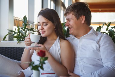 Beyaz elbise ve birlikte bir restoranda bir yaz günü dinlenme genç bir adam genç ve güzel esmer kadın