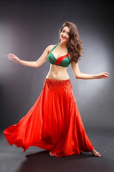 Beautiful belly dancer young woman in gorgeous red and green costume dress — Stock Photo, Image