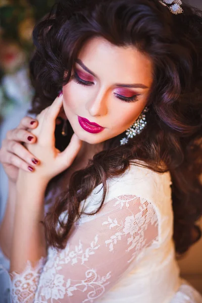 Close-up portrait of gorgeous beautiful bride in white dress with amazing hair style and make up, holding bouquet — Stock Fotó
