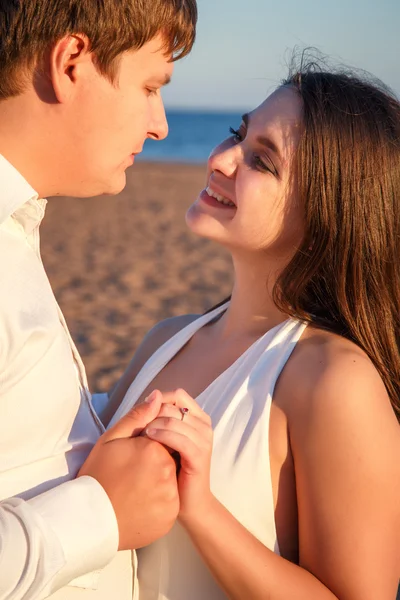 Hermosa pareja hombre y mujer descansa juntos en una playa en una noche de verano — Foto de Stock