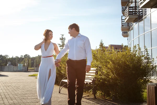 Hermosa pareja hombre y mujer descansa y camina juntos cerca de un edificio de lujo en un día de verano — Foto de Stock