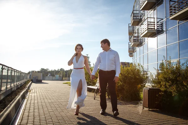 Hermosa pareja hombre y mujer descansa y camina juntos cerca de un edificio de lujo en un día de verano — Foto de Stock