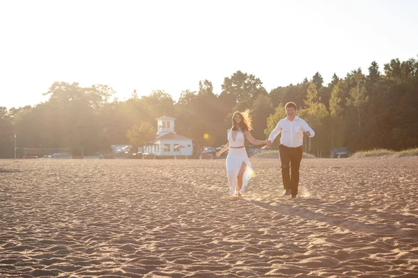 Para piękny mężczyzna i kobieta spoczywa wspólnie na plaży w letni wieczór — Zdjęcie stockowe