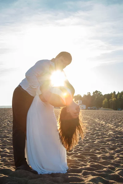 Belo casal homem e mulher descansa juntos em uma praia em uma noite de verão — Fotografia de Stock