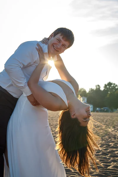 Vackra par man och kvinna vilar tillsammans på en strand i en sommarkväll — Stockfoto