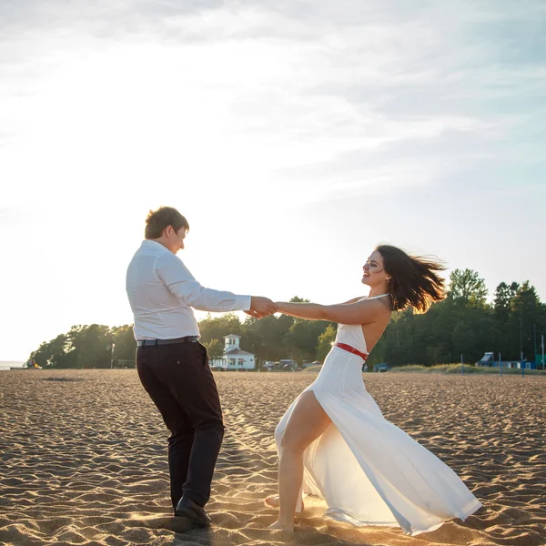 Belo casal homem e mulher descansa juntos em uma praia em uma noite de verão — Fotografia de Stock