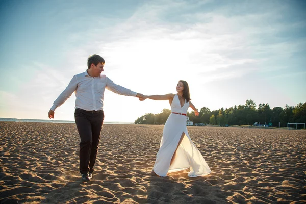 Hermosa pareja hombre y mujer descansa juntos en una playa en una noche de verano — Foto de Stock