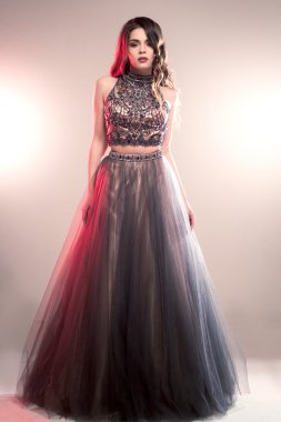 Lüks gece elbisesi içinde uzun kıvırcık saçlı güzel genç kadın moda Güzellik Portresi