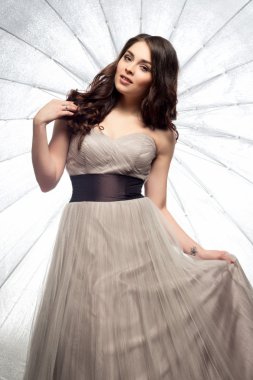 Lüks gece elbisesi içinde uzun kıvırcık saçlı güzel genç kadın moda Güzellik Portresi