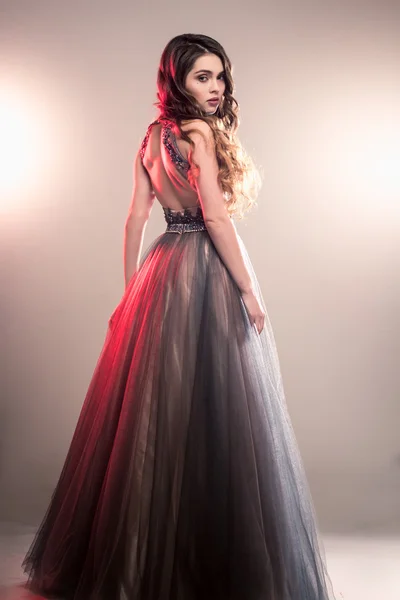Lüks gece elbisesi içinde uzun kıvırcık saçlı güzel genç kadın moda Güzellik Portresi