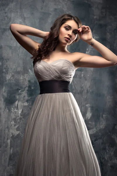 Mode schoonheid portret van prachtige jonge vrouw met lang krullend haar in luxe avondjurk — Stockfoto