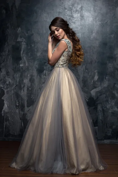 Lüks gece elbisesi içinde uzun kıvırcık saçlı güzel genç kadın moda Güzellik Portresi