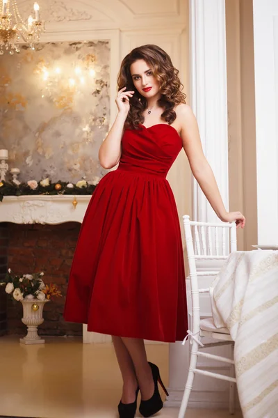 Hermosa mujer joven con maquillaje perfecto y estilo de pelo en magnífico vestido de noche rojo en el interior de lujo caro — Foto de Stock
