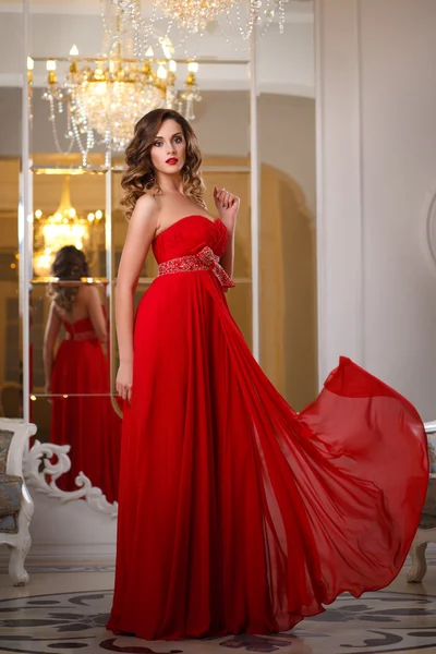 Mulher bonita com maquiagem perfeita e estilo de cabelo em lindo vestido de noite vermelho no interior de luxo caro — Fotografia de Stock