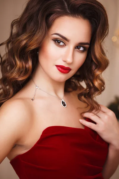Beautiful young woman with perfect make up and hair style in gorgeous red evening dress in expensive luxury interior Royalty Free Stock Images