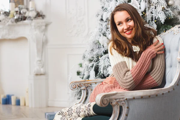 Portrait of a girl in winter clothes over light christmas background — Stock Photo, Image