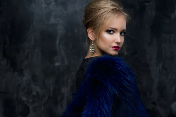 Nahaufnahme Porträt einer wunderschönen blonden jungen Frau im Promi-Stil mit perfektem Make-up und Frisur, die blaues Fell trägt. Mode Schönheit Foto, dramatisches Aussehen — Stockfoto