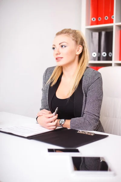 Hermosa mujer de negocios moderna en su oficina con una carpeta de papel y tableta de ordenador y teléfono móvil —  Fotos de Stock