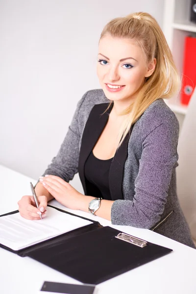 Bela mulher de negócios moderna em seu escritório com uma pasta de papel e tablet computador e telefone celular — Fotografia de Stock