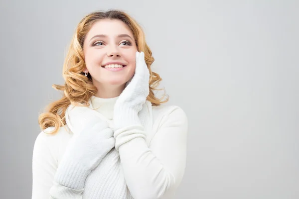 Retrato de cerca de una chica rubia en un jersey blanco cálido aislado sobre fondo blanco — Foto de Stock
